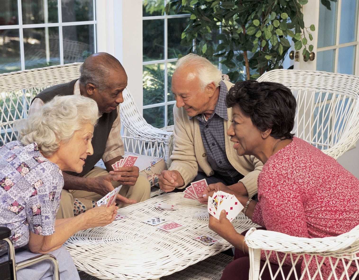 Seniors gathered around a table playing cards