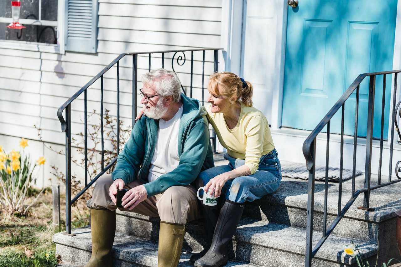 Senior couple sitting on their porch steps