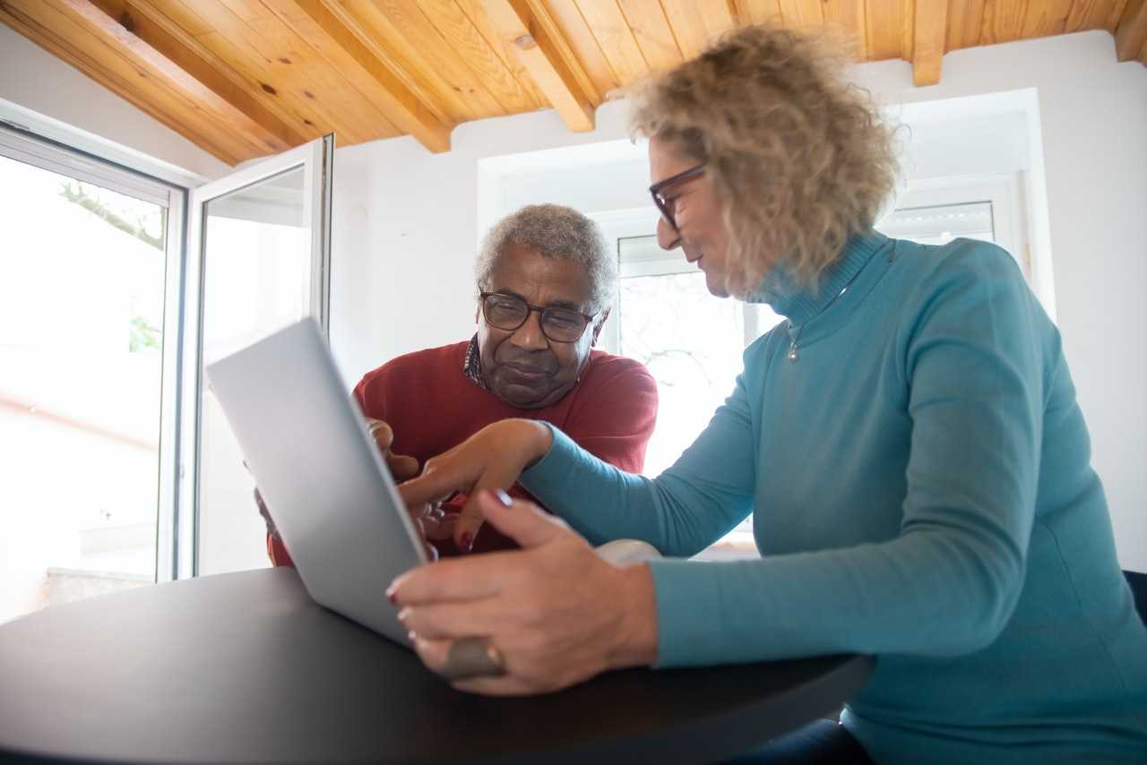 Two seniors looking at a laptop