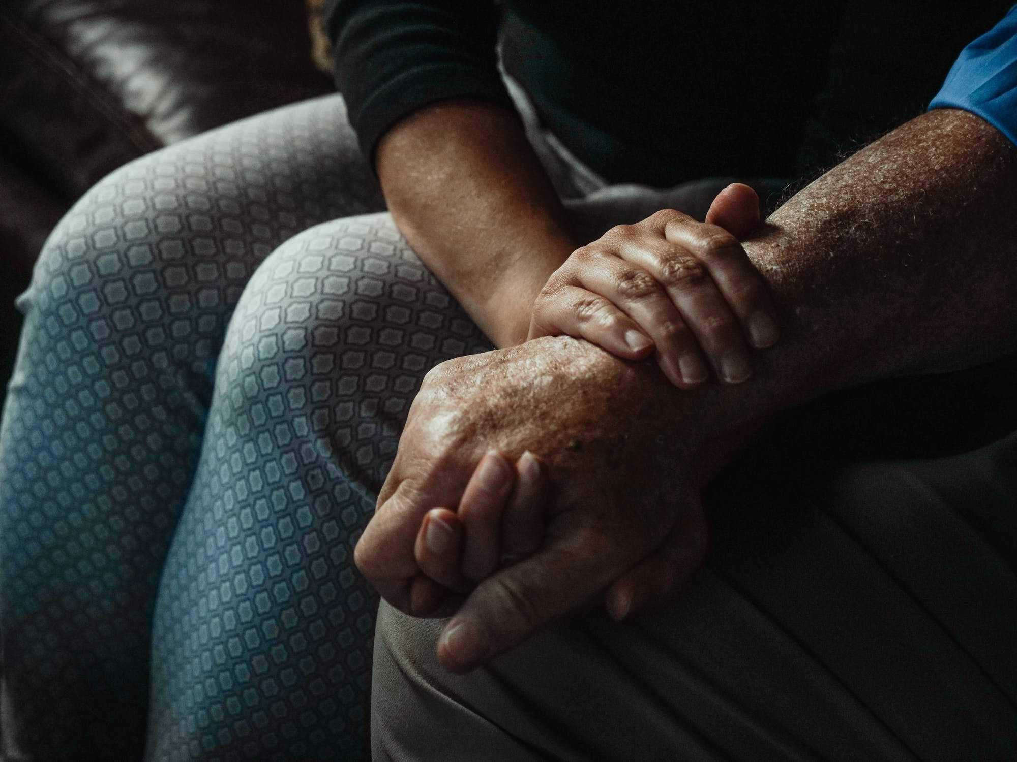 Woman holding hands with an elderly man