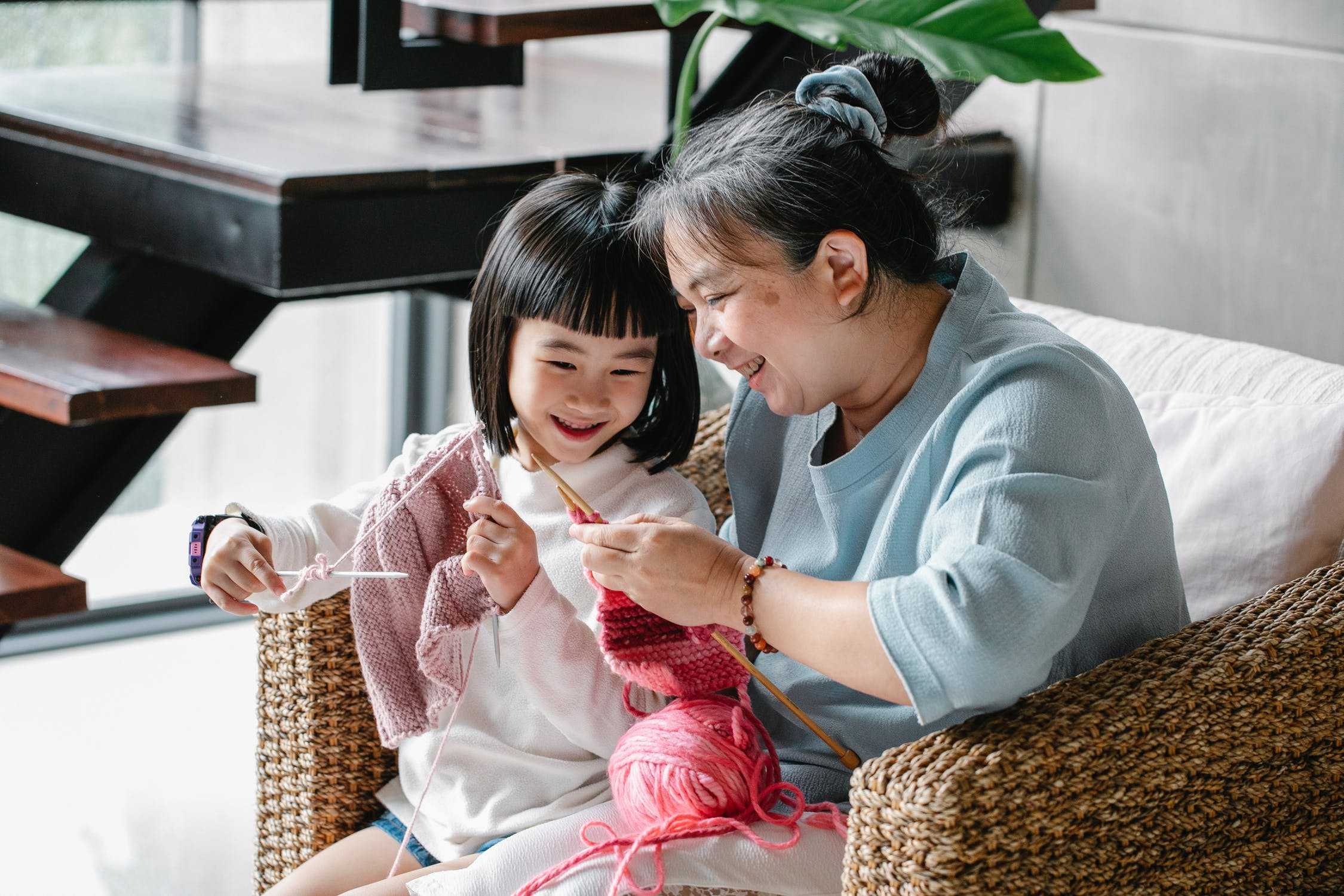 Grandmother teaching her granddaughter to knit