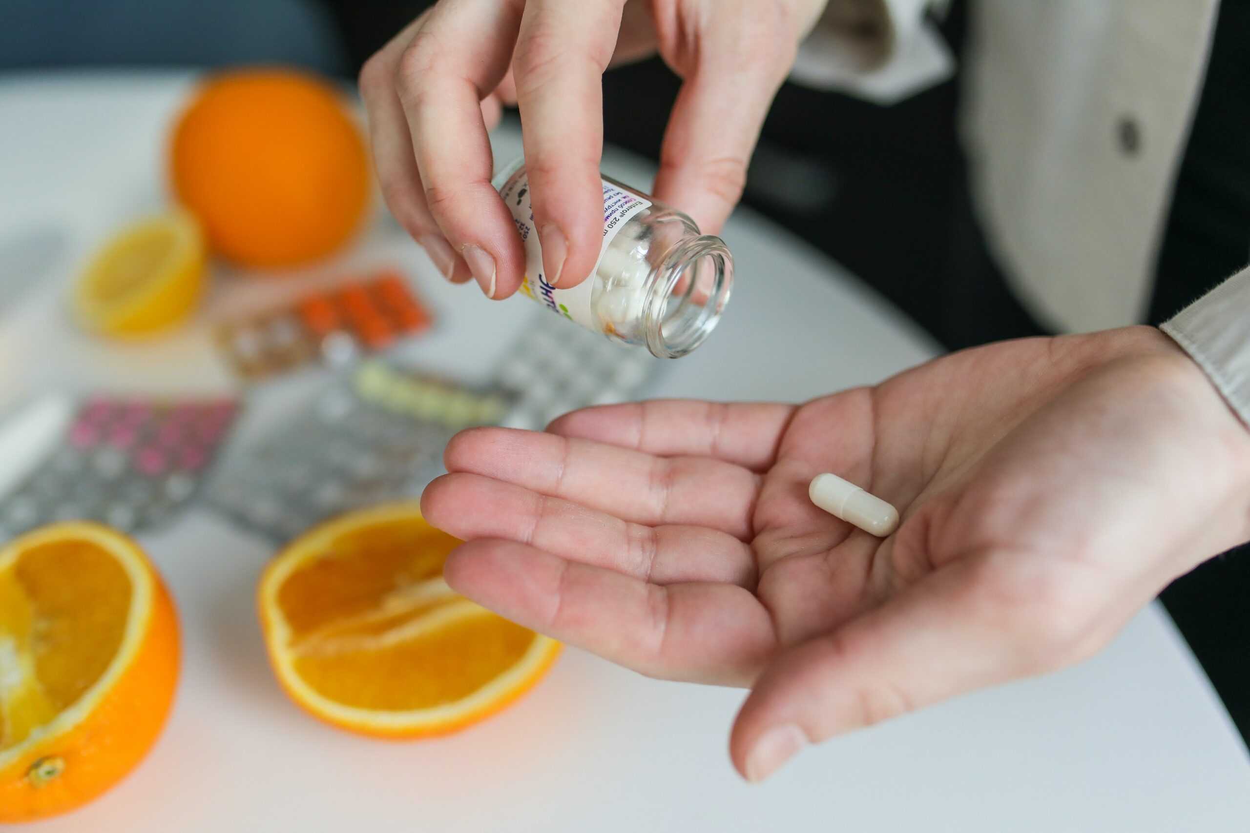 hands holding a pill and pill bottle