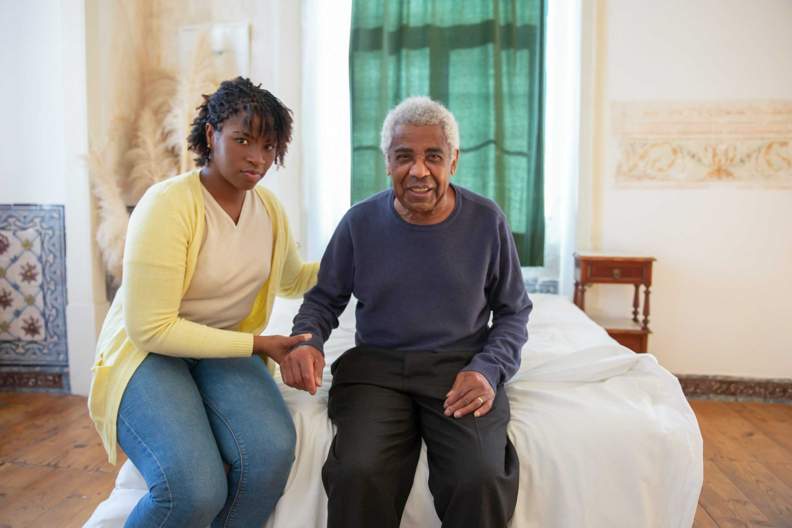elderly man with woman sitting on bed